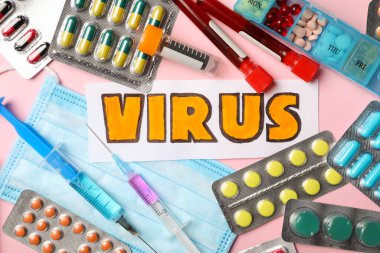 VIRUS sözcüğüyle düz kompozisyon ve pembe arka planda ilaçlar