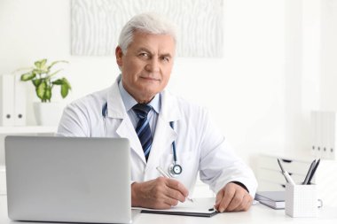 İş yerinde beyaz önlüklü kıdemli doktorun portresi.
