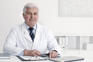 İş yerinde beyaz önlüklü kıdemli doktorun portresi.