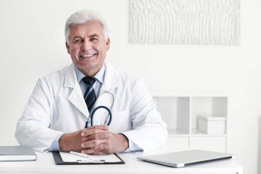 İş yerinde beyaz önlüklü kıdemli doktorun portresi.