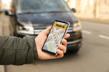 Şehir caddesinde akıllı telefondan taksi çağıran adam, yakın plan.
