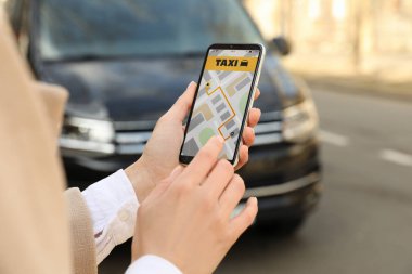 Şehir caddesinde akıllı telefondan taksi çağıran kadın, yakın plan.