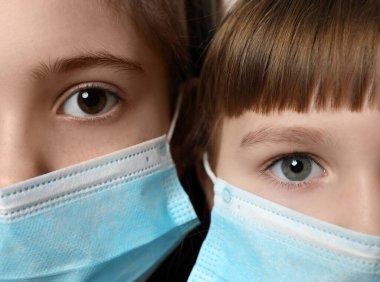 Tıbbi maskeli küçük kızlar, yakın plan. Virüs koruması