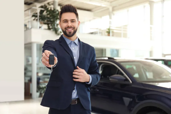 Verkäufer Mit Schlüssel Modernem Autosalon — Stockfoto