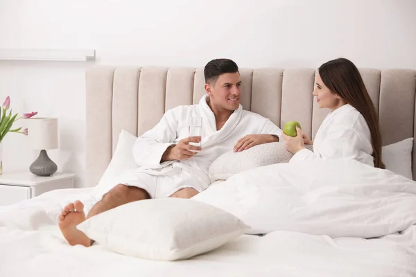 幸福的夫妻穿着浴衣躺在床上 — 图库照片