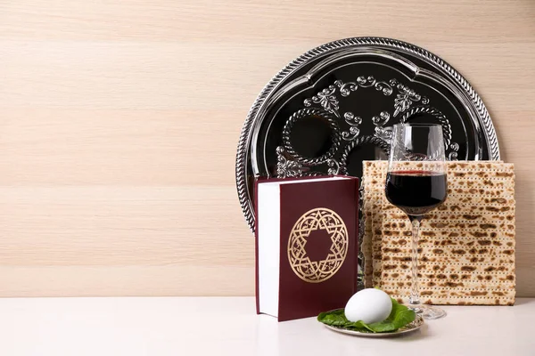 Symbolische Pesach Pesach Seder Voorwerpen Witte Tafel Tegen Houten Ondergrond — Stockfoto