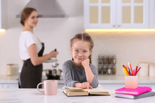 Petite Fille Faire Ses Devoirs Tandis Que Mère Cuisine Dans — Photo