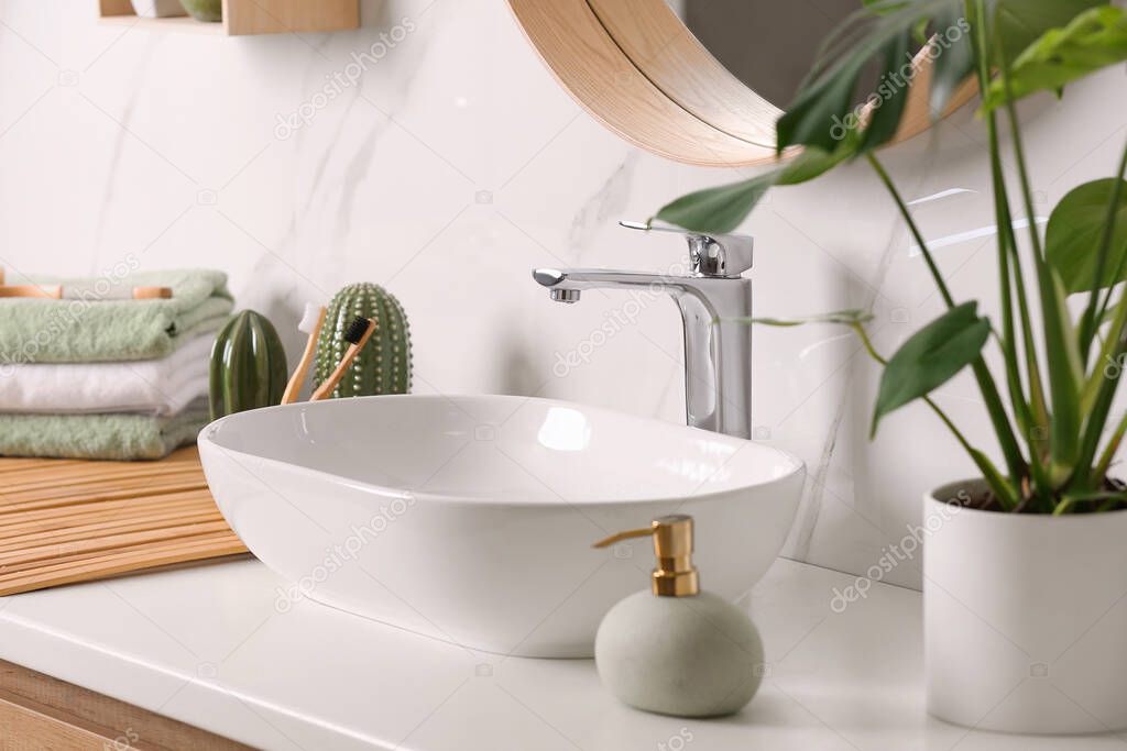 Stylish vessel sink on light countertop in modern bathroom