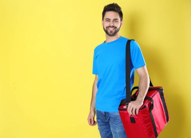 Sarı arka planda termo çantalı kurye, mesaj için yer var. Yemek dağıtım servisi.