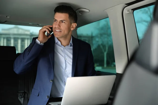 Hombre Guapo Con Portátil Hablando Teléfono Inteligente Coche Moderno — Foto de Stock