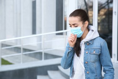 Açık havada tek kullanımlık maske takan bir kadın. Tehlikeli bir virüs.