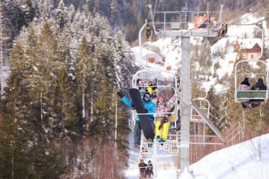 Dağ kayak merkezindeki teleferiği kullanan çift. Kış tatili