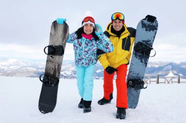 Tepede snowboard yapan sevimli bir çift. Kış tatili