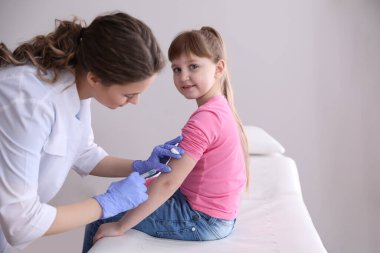 Klinikte suçiçeği aşısı olan küçük bir kız. Varicella virüs önleme