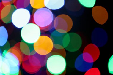 Siyah arkaplandaki renkli ışıkların bulanık görüntüsü. Bokeh etkisi