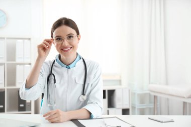 İş yerinde beyaz önlüklü genç kadın doktor portresi