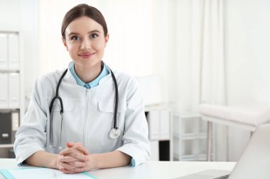 İş yerinde beyaz önlüklü genç kadın doktor portresi