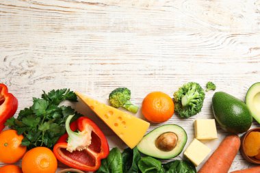 A vitamini açısından zengin taze ürünler beyaz ahşap masada, düz yerde. Metin için boşluk