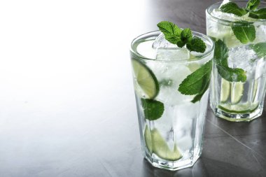 Açık gri masada buzlu Mojito kokteyli, yakın plan. Metin için boşluk