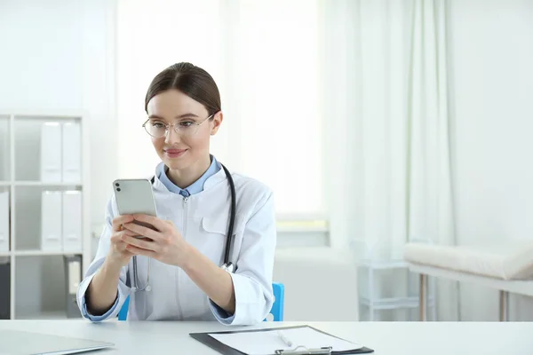 Ung Kvinnlig Läkare Med Smartphone Vid Bordet Kontoret — Stockfoto