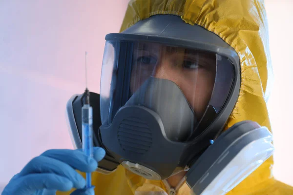 色の背景に注射器と化学保護スーツの科学者 クローズアップ — ストック写真