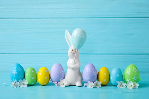 复活节兔子和彩绘蛋浅蓝色木制背景 — 图库照片