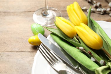 Ahşap arka planda çiçek desenli Paskalya sofrası, yakın plan.