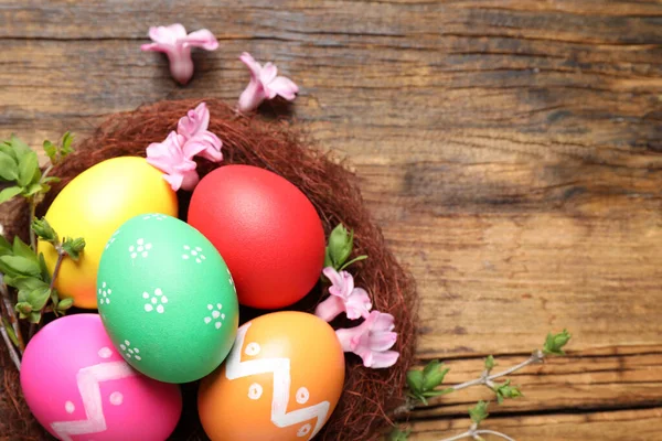 Huevos Pascua Coloridos Nido Decorativo Con Flores Sobre Fondo Madera —  Fotos de Stock
