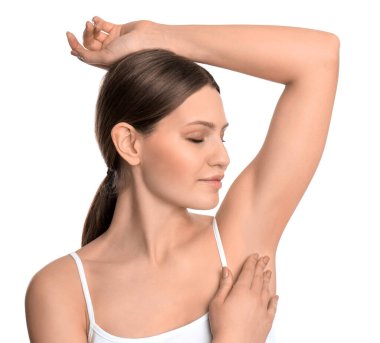 Genç ve güzel bir kadın, beyaz arka planda pürüzsüz, temiz bir ciltle koltukaltı gösteriyor.