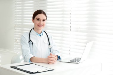 İş yerinde beyaz önlüklü genç kadın doktor portresi