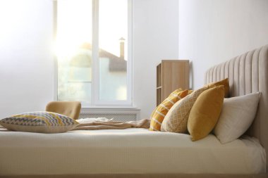 Şık oda içinde yumuşak yastıklı rahat bir yatak.