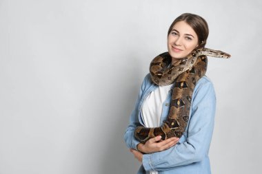 Arka planda boa yılanı olan genç bir kadın, mesaj için yer var. Egzotik hayvan