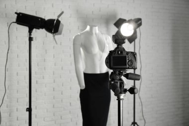 Hayalet mankenler ve modern stüdyoda profesyonel ışıklandırma ekipmanları üzerinde şık kıyafetler. Moda fotoğrafçılığı