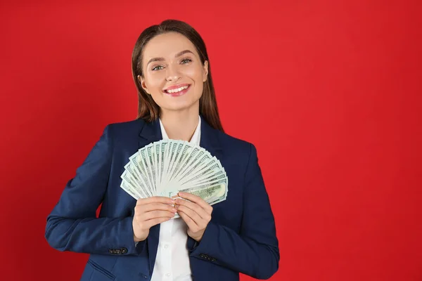 真紅の背景にお金を持つ若い女性 テキストのスペース — ストック写真