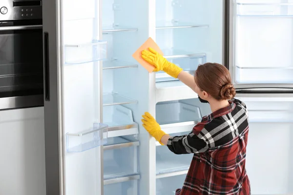 家中穿着橡胶手套清洁冰箱的女人 — 图库照片
