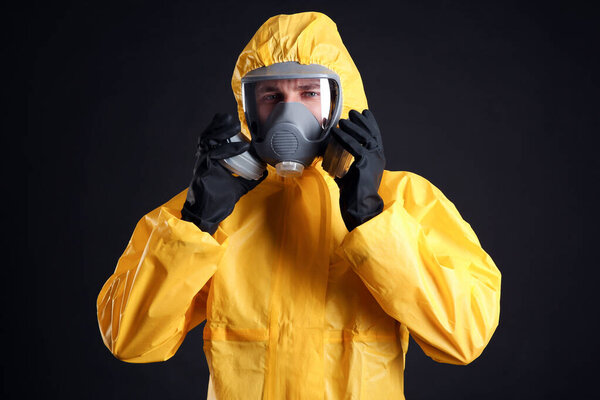 Man wearing chemical protective suit on black background. Virus research