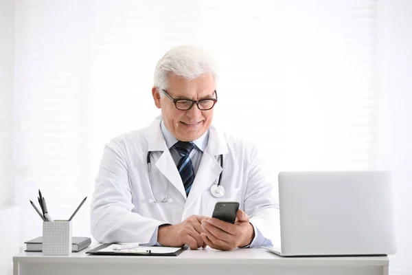 Médico Sênior Com Smartphone Mesa Escritório — Fotografia de Stock