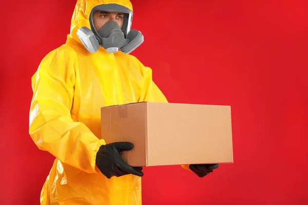 Homem Vestindo Terno Proteção Química Com Caixa Papelão Fundo Vermelho — Fotografia de Stock