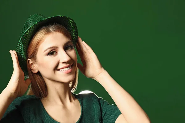 Young woman in green outfit on color background. St. Patrick\'s Day celebration