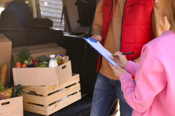 Vrouw Tekent Voor Het Ontvangen Van Verse Producten Buurt Van — Stockfoto