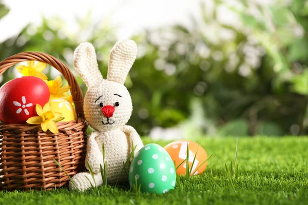 五彩缤纷的复活节彩蛋 玩具兔子和水仙花 绿草丛生 案文的篇幅 — 图库照片