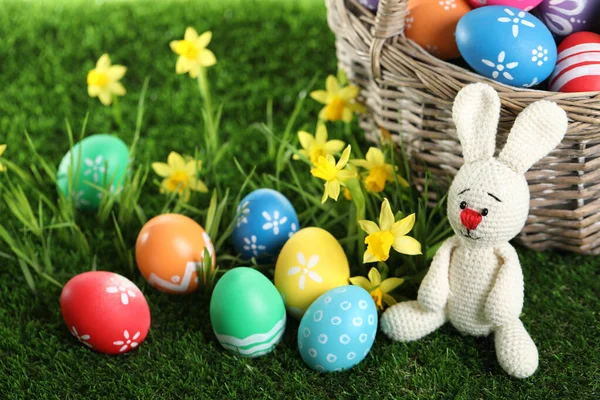五彩缤纷的复活节彩蛋和绿草上的玩具兔子 — 图库照片