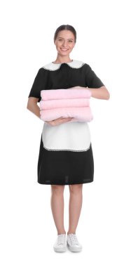 Genç oda hizmetçisi beyaz arka planda temiz havlular tutuyor.