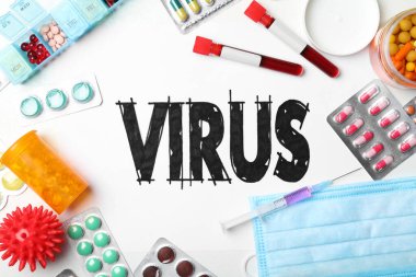 Beyaz zemin üzerinde VIRUS kelimesi ve ilaçlar bulunan düz kompozisyon