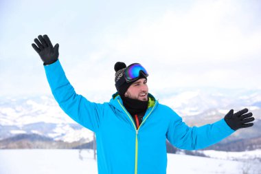 Dağın eteklerindeki genç adam. Kış tatili