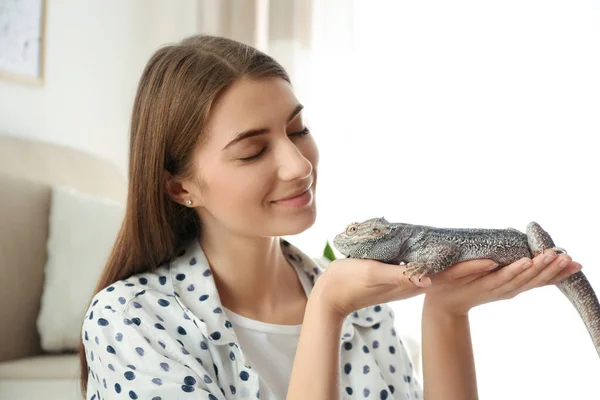 Woman holding bearded lizard at home. Exotic pet