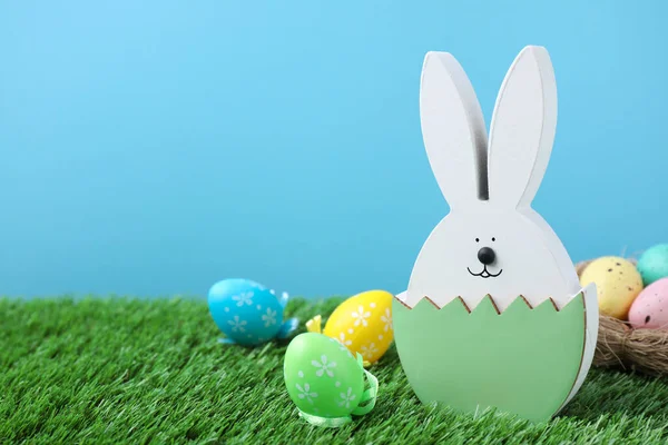 复活节兔子形象和染色蛋绿色的草地上的浅蓝色背景 案文的篇幅 — 图库照片