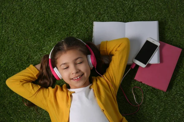 Cute Little Girl Słuchanie Audiobook Trawie Widok Góry — Zdjęcie stockowe