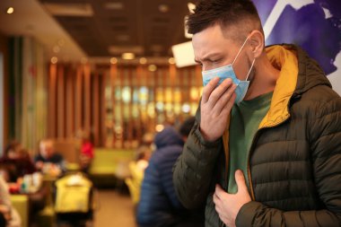 Kafede tek kullanımlık maskeli bir adam. Virüs koruması