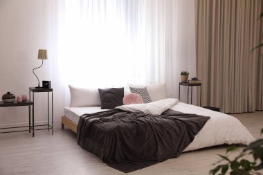 Büyük, rahat bir yatağı olan şık bir oda.